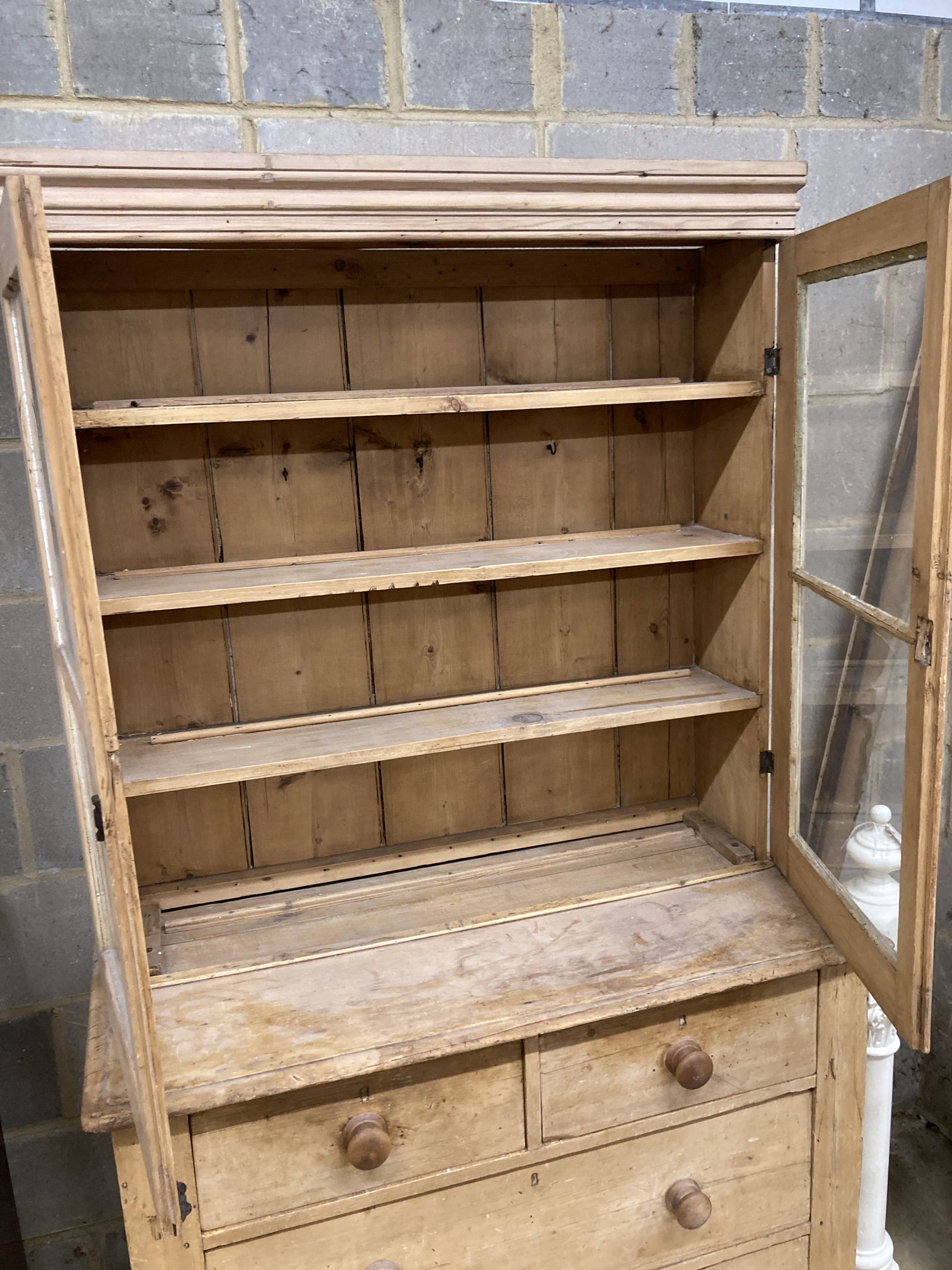 A Victorian glazed pine cabinet on chest, width 112cm, depth 50cm, height 195cm